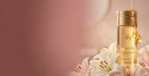 O Boticário Lily Perfumed Body Oil bottle with liquid gold texture and Stargazer Lily flowers for scent layering and 48-hour perfume longevity